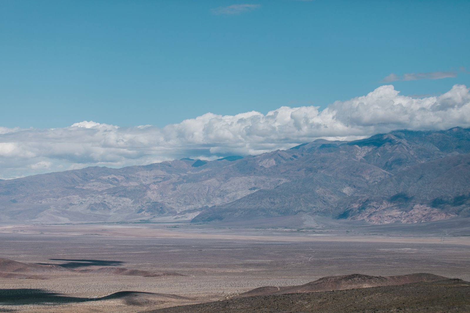 Broad arid basin and gray mountains, illustrative landscape for Fallon rural well and septic services